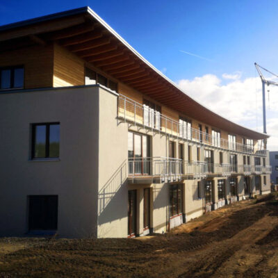 Picture of a residential complex whose top floor is built with LORENZ DD34 mounting systems made of wood and straw