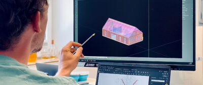 Man with pencil checks AutoCAD 3-D model of a house on the screen - LORENZ makes all its products with the possible construction methods available as digital building blocks